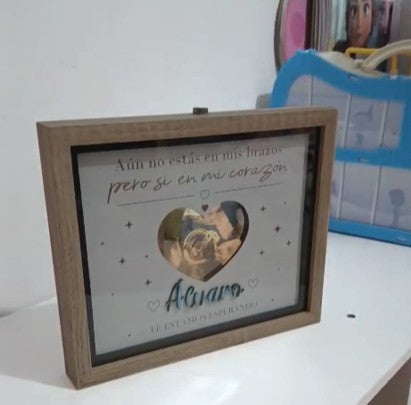 Cuadro de madera natural con luz LED, personalizado con ecografía de bebé, nombre 'Alvaro' y frase 'Aún no estás en mis brazos pero sí en mi corazón'.